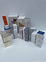 Photo showing multiple Avon Anew skincare products in their boxes arranged on a white surface, mostly factory sealed.