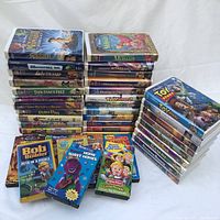 Full lot of assorted children's VHS movies and shows stacked and spread out showing various titles and colorful cases.