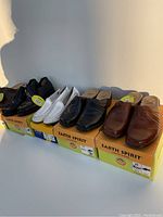 Four pairs of ladies shoes on their original Earth Spirit shoe boxes arranged side by side: black, white, black, and brown colors visible.