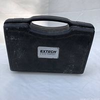 Black hard plastic carrying case with Extech logo on front