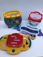 Photo showing all five kids toys including fish bowl, learning drum, laptop, carrier bar, and musical toy bar.