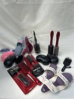 Image showing assortment of hair brushes including packaged and loose brushes in different shapes and colors.