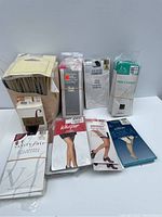 Overview of assorted packages of pantyhose, footlets, and knee highs from multiple brands, neatly arranged upright.