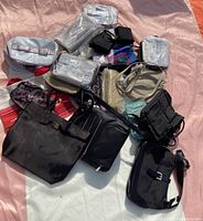 Overview of multiple purses and cosmetic bags in various colors and packaging, showing quantity and variety of lot