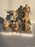 All five Sarah's Angels figurines on white foam, showing variety of sizes and musical instruments including the largest angel holding a light-up orb.