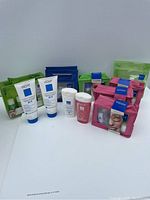 Photo showing multiple Vichy skincare products arranged including 3 sample pouches in green, blue, and pink, two tubes of Pureté Thermale 3-in-1 cleanser, a large bottle of Pureté Thermale toner, a white bottle of cleansing milk, and a spray bottle of thermal water.