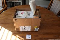 Cardboard box on table containing all candy making supplies.