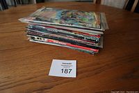 Stack of assorted comic books on a wooden table