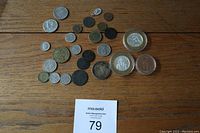 Overview of mixed coins on wooden surface including Las Vegas gaming tokens in plastic cases