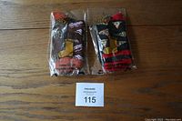 Two pairs of packaged novelty socks shown side by side on wooden floor.