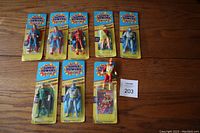 Nine figures laid out on wooden surface showing all cards and open figure