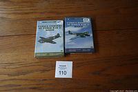 Two World War 2 plane DVDs on a wooden surface, showing front covers with illustrations of a fighter and bomber aircraft respectively.