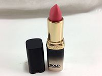 Photo of open L'Oreal Colour Riche Gold Addiction lipstick shade 958 Pink Gold with cap removed showing pink matte lipstick bullet and gold inner tube.