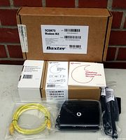 Full view of the Baxter 5C6M70 Modem Kit components including boxes, cables, and the modem.