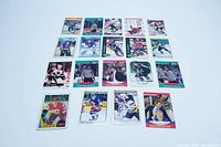 Set of 19 hockey cards arranged flat on white background showing various players and referees in colorful uniforms and team logos.