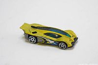 The Side Draft yellow Hot Wheels die cast toy car angled front left showing aerodynamic design, domed windshield, and wheel detail.