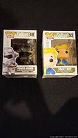 Photo showing unopened boxed Power Armor (#49) and Vault Boy (#53) Fallout Funko Pop figures.