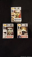 Three unopened boxed Funko Pop figures: First Order Stormtrooper #66, Han Solo Snow Gear #86 Loot Crate exclusive, Scarif Stormtrooper #145.