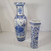 Photo showing both large and small blue and white vases side by side on white background.
