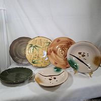 Full view of the six Japanese inspired kitchen plates arranged upright and lying flat, showing their various patterns and colors.
