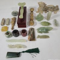 Overview of entire lot showing all items arranged on white cloth including jade carvings, seals, bangles, and figurines.