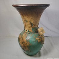 Front view of large handmade rustic pottery vase, showing wide flared rim and turquoise blue distressed finish with natural clay tones.