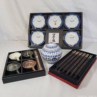 Full set including six plates, four sauce dishes, lidded jar, chopsticks, and chopstick rests arranged in trays