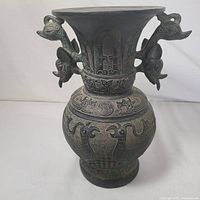 Front view of the carved Zun pillar shaped vase with animal motif handles and decorated body