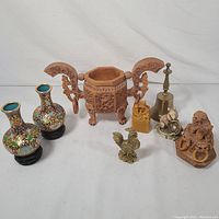 Full image showing all items including the foo dog incense burner, cloisonné vases, brass bell, brass rooster, carved seal, and small foo dog figurine