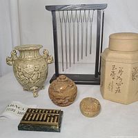 Overview of all items in the lot showing tea canister, vase, chime, small carved containers, and abacus