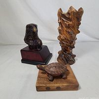Image showing all three items together: eagle bust statue sculpture, tall wood vase, small wooden turtle figurine.
