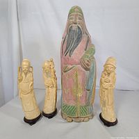 Set of four vintage Japanese wise man standing figurines together, showing size difference and overall appearance.