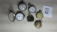 Overview of six assorted pocket watches on table