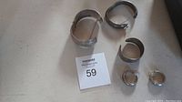 Full lot view showing two bracelets and one pair of earrings arranged beside a MaxSold tag