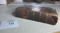 Antique leather-bound book with wear on spine and cover.