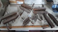 Photo showing all six wood clamps arranged on a table, four large and two smaller clamps with wooden bodies and metal screw mechanisms.