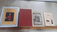Four military history books related to Kingston and Old Fort Henry on white surface, with a measuring ruler below for scale.