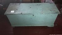 Front view of closed chest showing painted top and front face with chipping paint