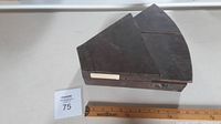 Closed dark-stained wooden wedge case shown next to ruler