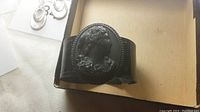 Photo of the black Whitby jet bracelet showing the oval cameo of a woman's profile with floral details and the bracelet's smooth band.