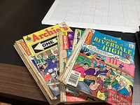 14 worn Archie comic books arrayed in a stack showing various colorful illustrated covers including 'Archie at Riverdale High' and 'Archie One'.