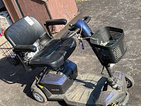 Side and top view of blue and black Go Go LX mobility scooter with CTS suspension, showing padded seat with armrests, basket on handlebar, and footrest area.