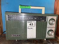 Full front view of the Sony transistor radio showing the tuning and volume dials, frequency display, handle, and Sony logo.