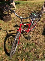 Red Raleigh Safari ladies 6-speed bicycle, front side view showing frame, front wheel, handlebars, and front fender on grass outdoors.