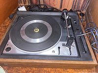 Full view of the Dual 1225 record player showing the turntable, tonearm, and controls within a wooden housing.