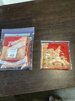 Two sealed packages of Canada-themed multi-functional headwear in ziplock bags on a wooden table.