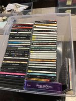 Full assortment of CDs arranged in a plastic container, showing colorful spines with artist and album details.