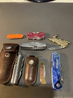 Overview of all pocket tools and box cutters arranged on table showing variety of brands and styles