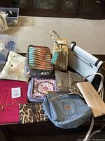 Full view of all purses together on floor showing variety of styles and colors.