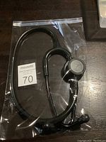 Black stethoscope with silver chest piece inside clear plastic bag from two different angles.